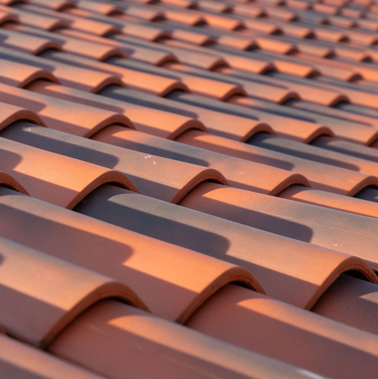 A close up of a row of red tiles on a roof