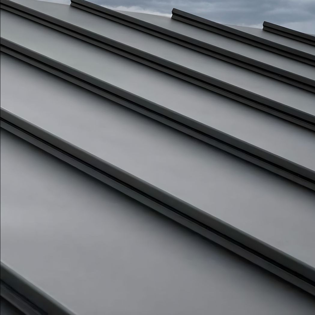 A close up of a gray metal roof with a blue sky in the background.
