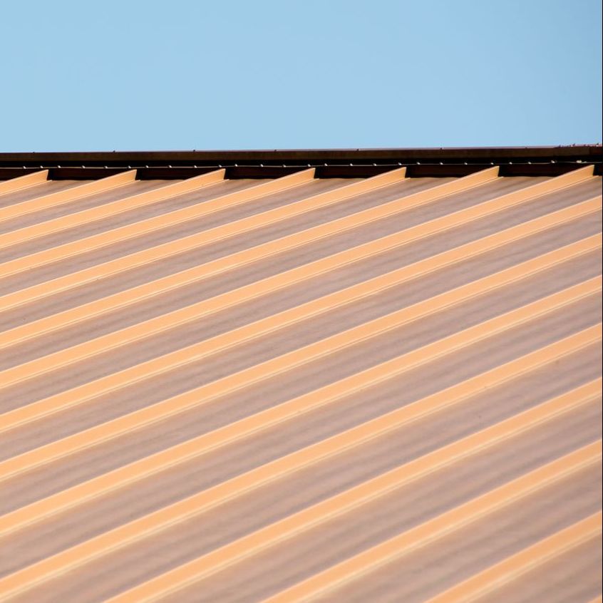 A close up of a roof with a blue sky in the background