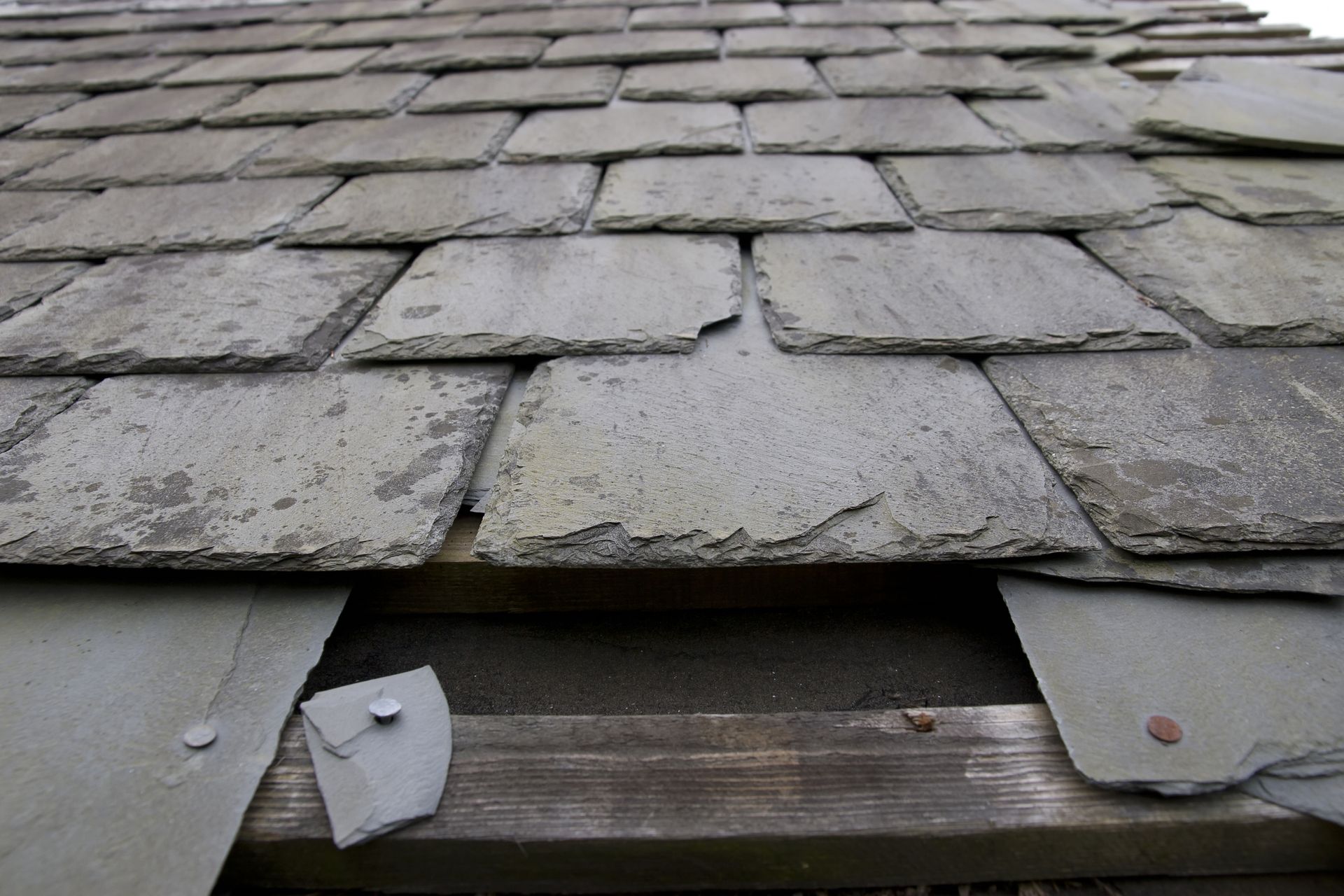 A roof with damage slate tiles