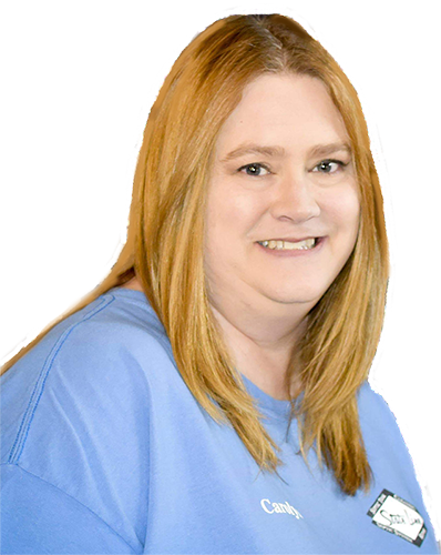 A woman with red hair is wearing a blue shirt and smiling.