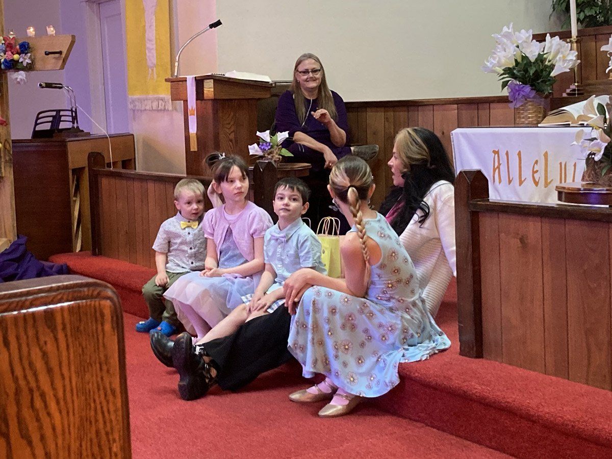 A group of people are sitting on the steps of a church.