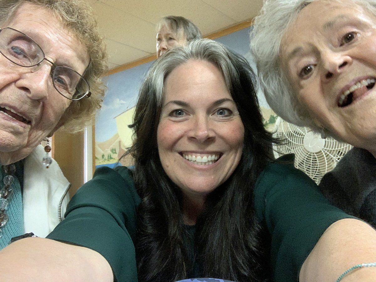 Three women are posing for a picture together and smiling.