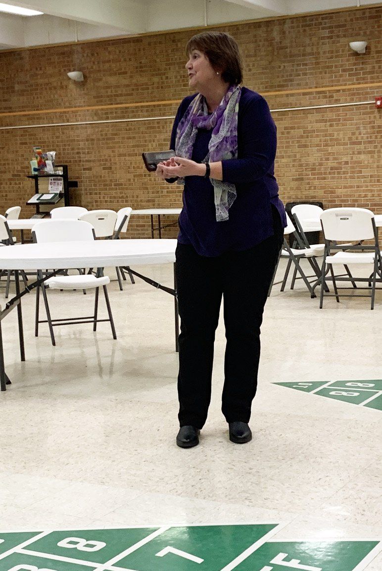 A woman standing in a room with tables and chairs