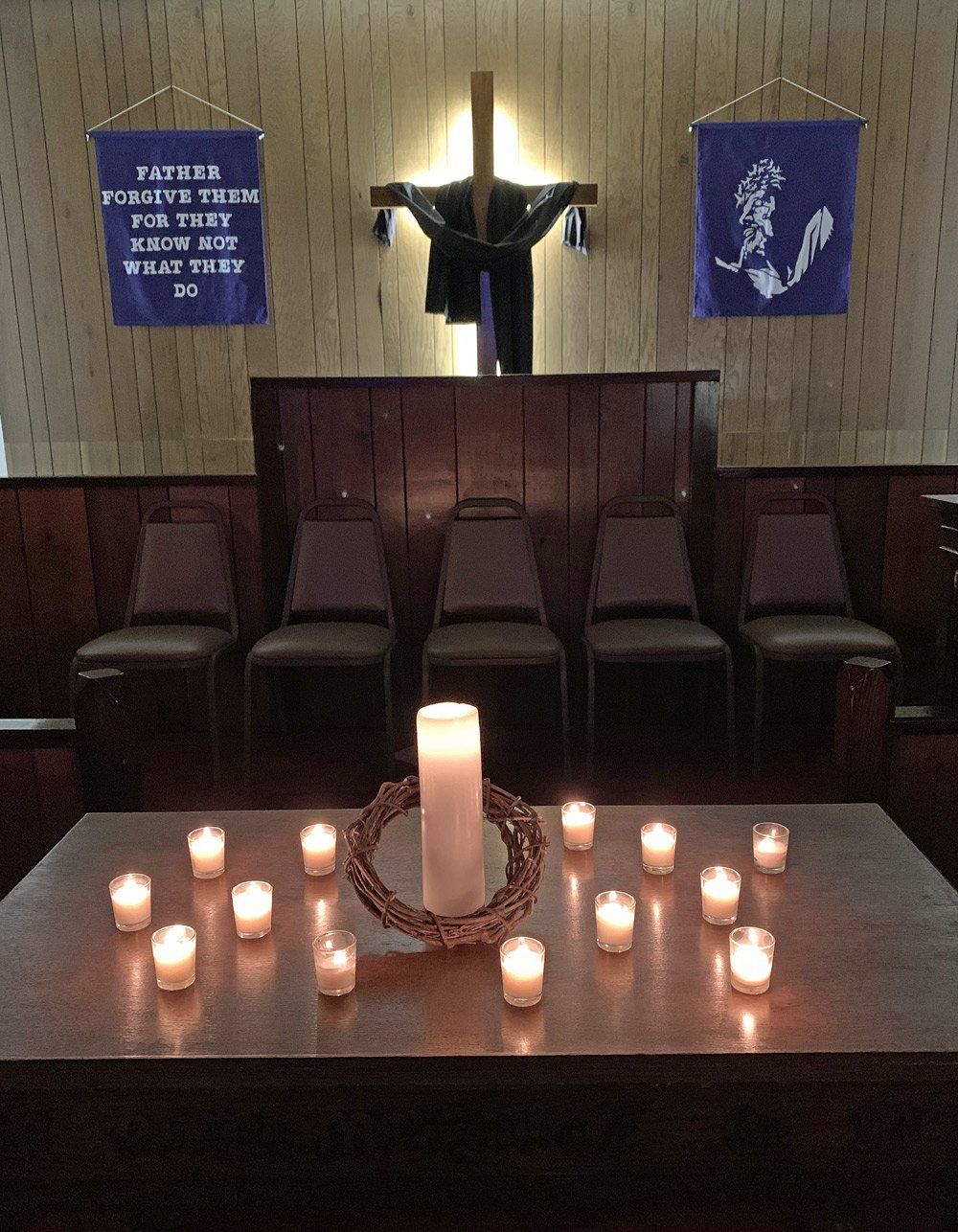 A table with candles and a cross in the background