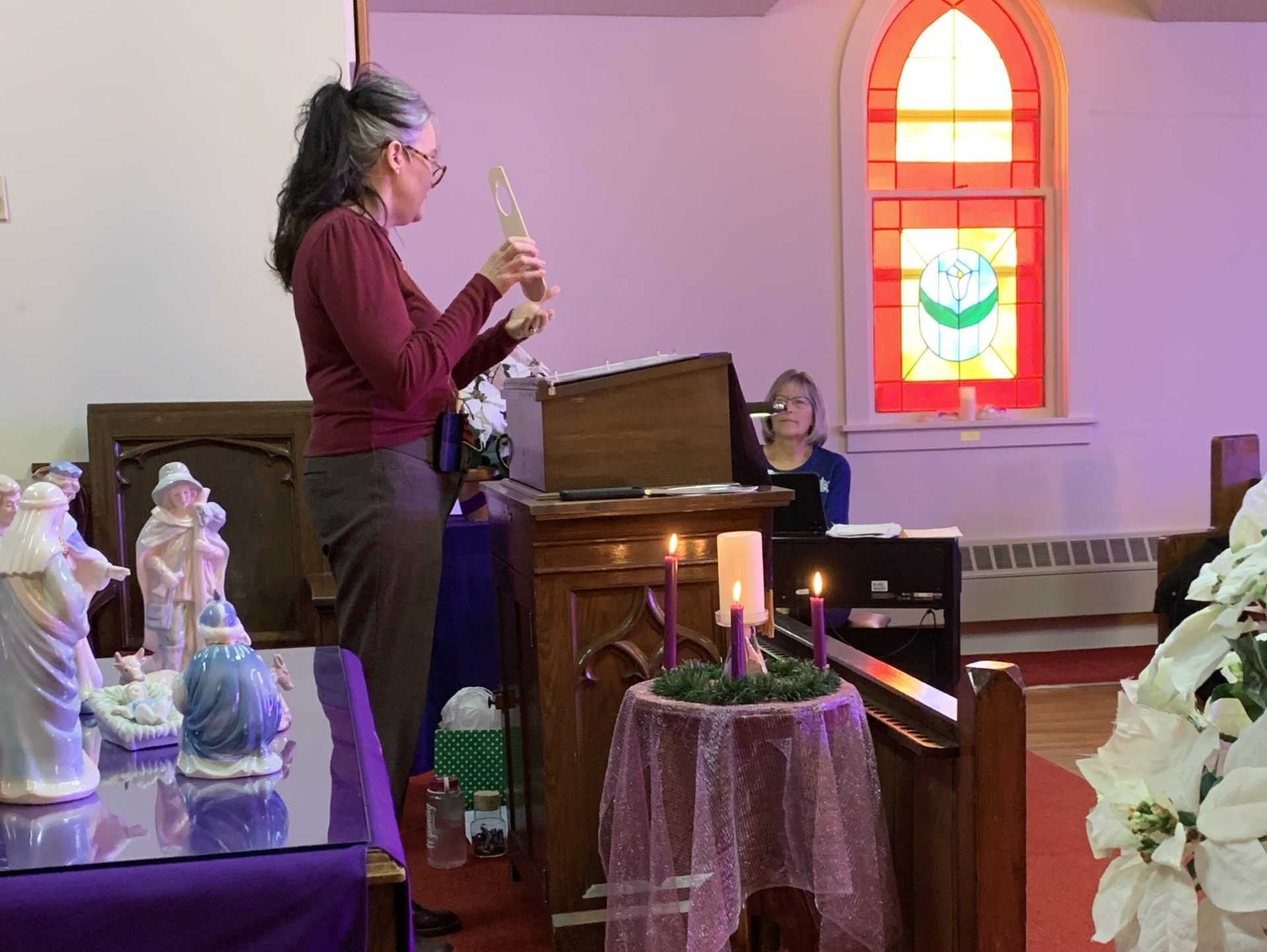 Pastor Virgie is standing in a church holding a candle.