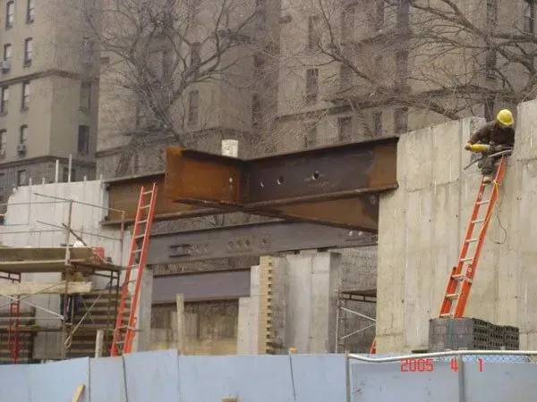 A Man On A Ladder Is Working On A Building — Albertson, NY — Patsy Strocchia & Sons Ir
