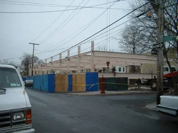 A White Van Is Parked In Front Of A Building Under Construction — Albertson, NY — Patsy Strocchia & Sons Ir
