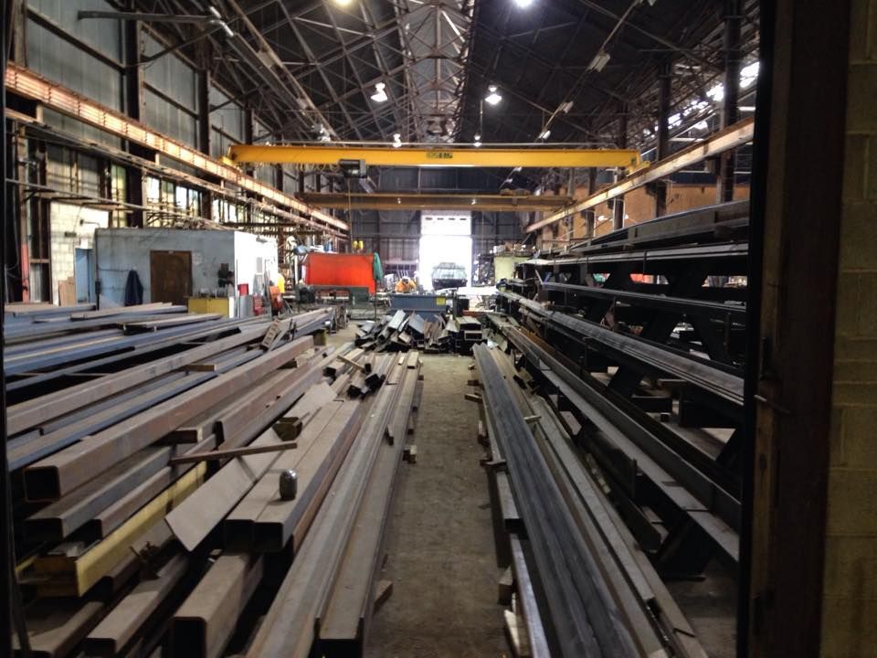 A Bunch Of Metal Pipes Are Stacked On Top Of Each Other In A Warehouse — Albertson, NY — Patsy Strocchia & Sons Ir
