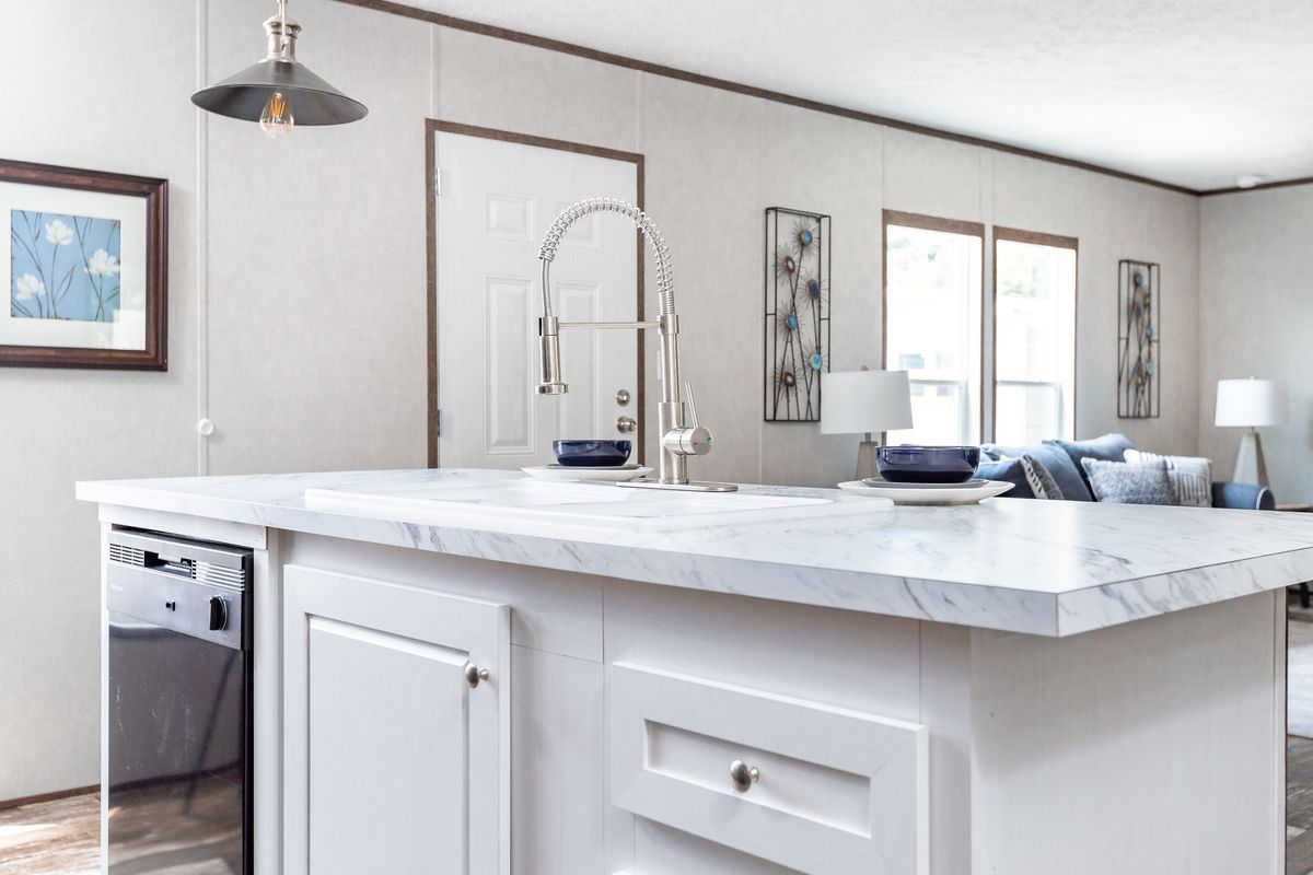 A kitchen with a large island , sink , and dishwasher.