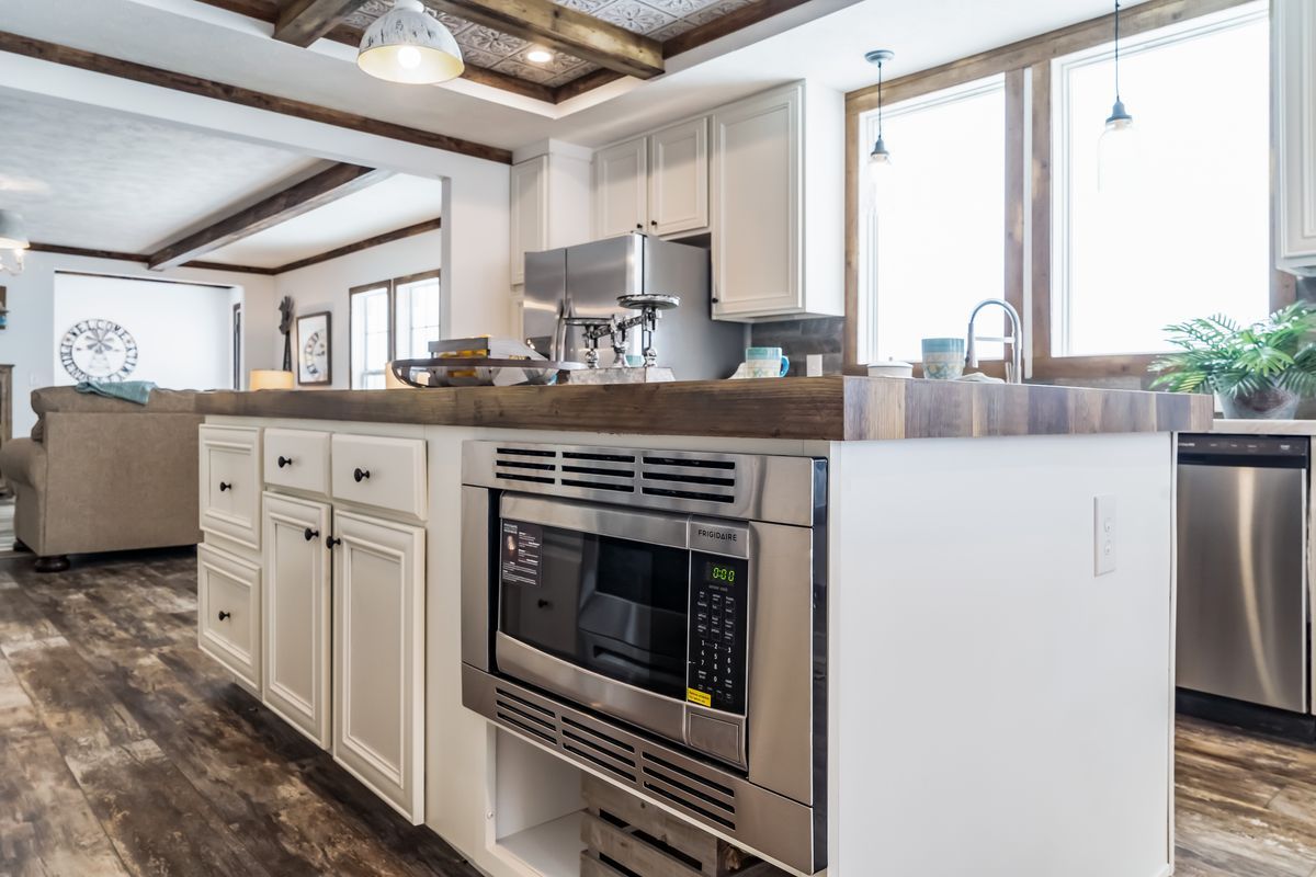 A kitchen with stainless steel appliances and a microwave oven.