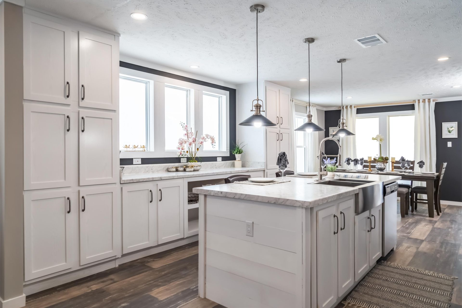A kitchen with white cabinets and a large island in the middle.