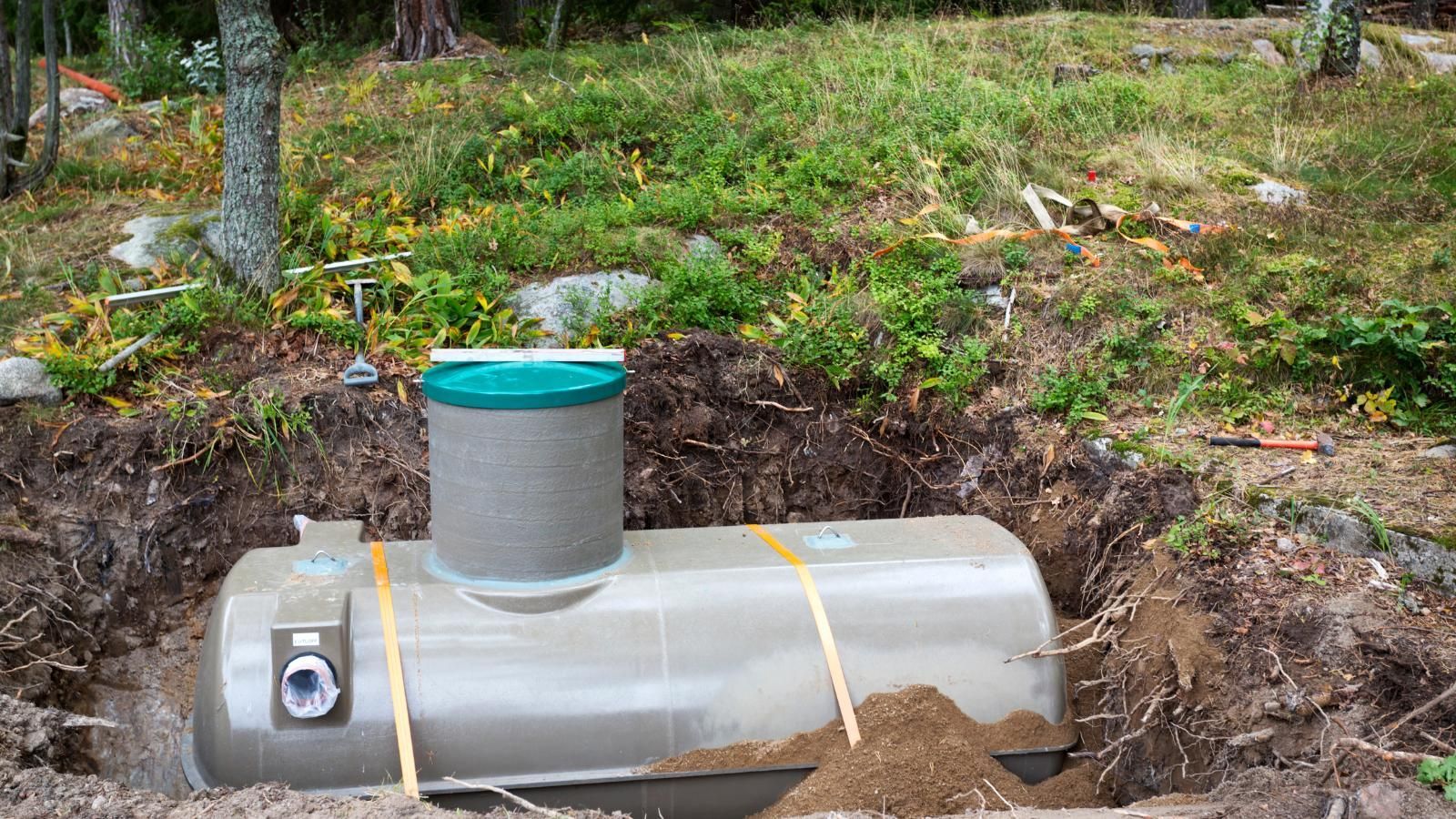 A large septic tank is sitting in the middle of a trench.