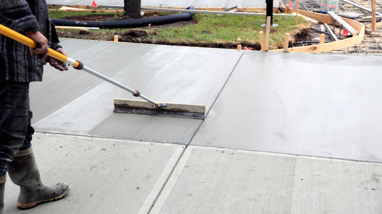 Smoothing a concrete driveway during installation.