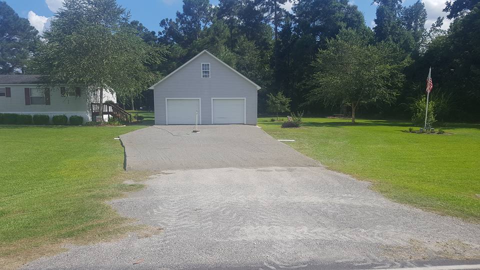 gravel driveway installation in front of barn