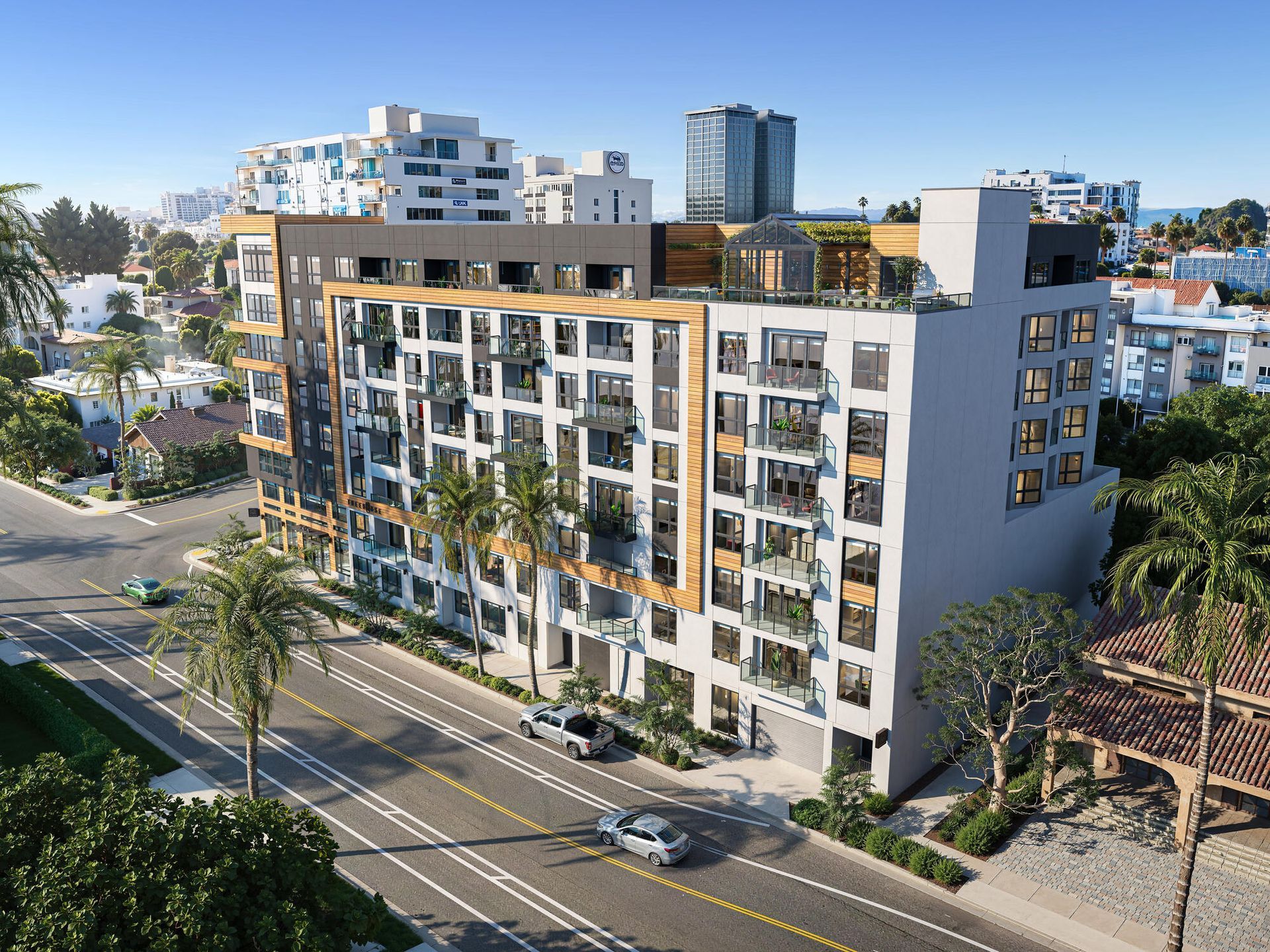 Modern apartment building on a street with palm trees and cars, in a sunny urban setting.