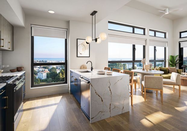 Modern kitchen and dining area with ocean views, hardwood floors, and marble island.