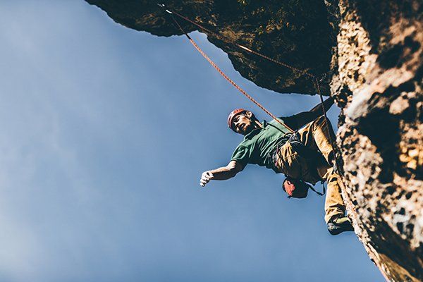 A rock climber viewed from below.