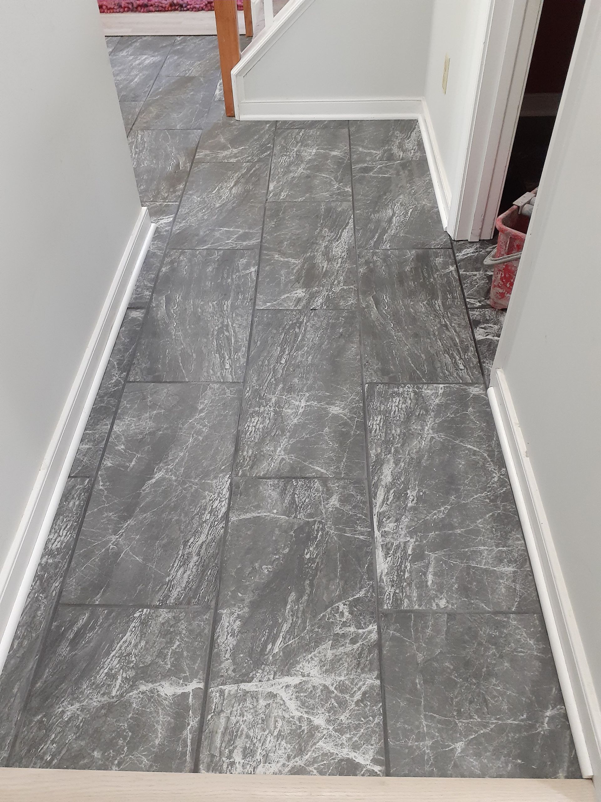 Dark gray tile floor in hallway, white trim on walls.