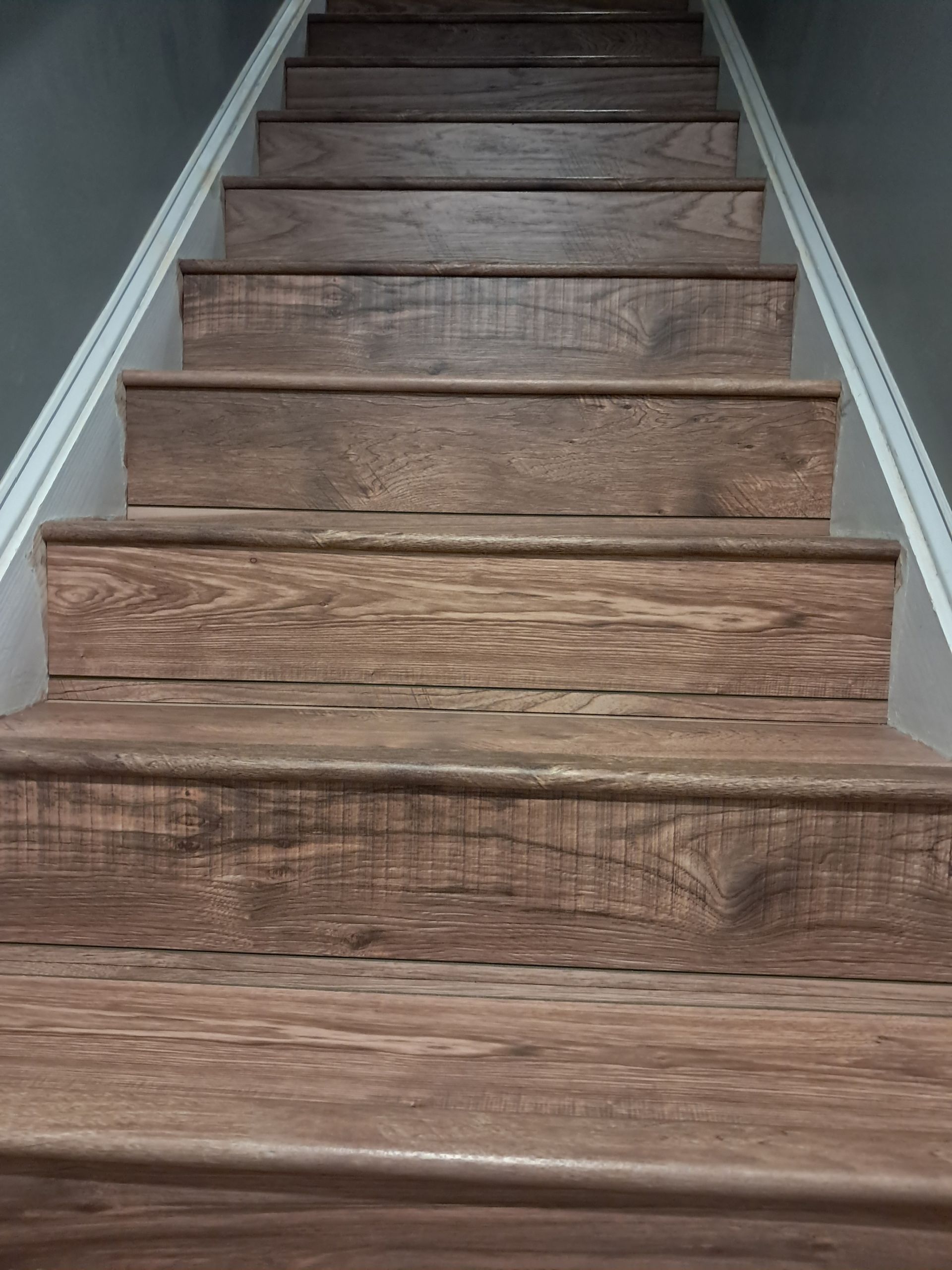 Wooden staircase with dark wood treads and white trim, leading upwards.