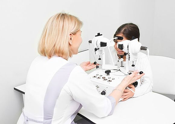 Doctor checking eyesight of a girl — Munster, IN — Munster Eye Care Associates
