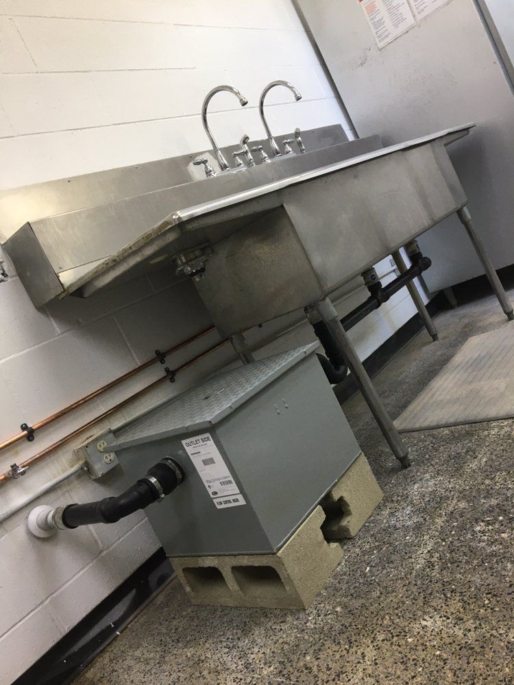 A stainless steel sink with two faucets is in a kitchen.