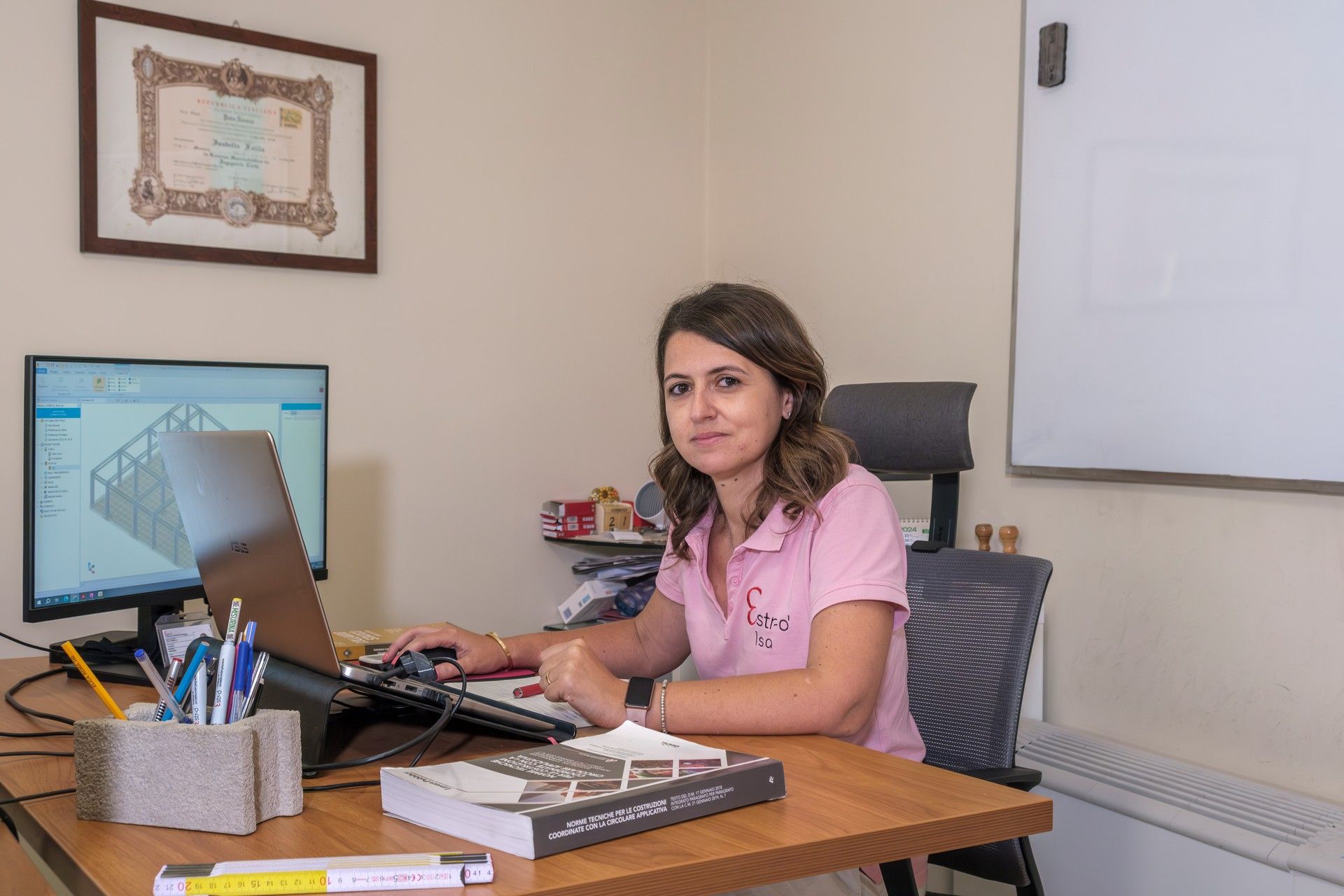 Una donna è seduta alla scrivania davanti a un computer.