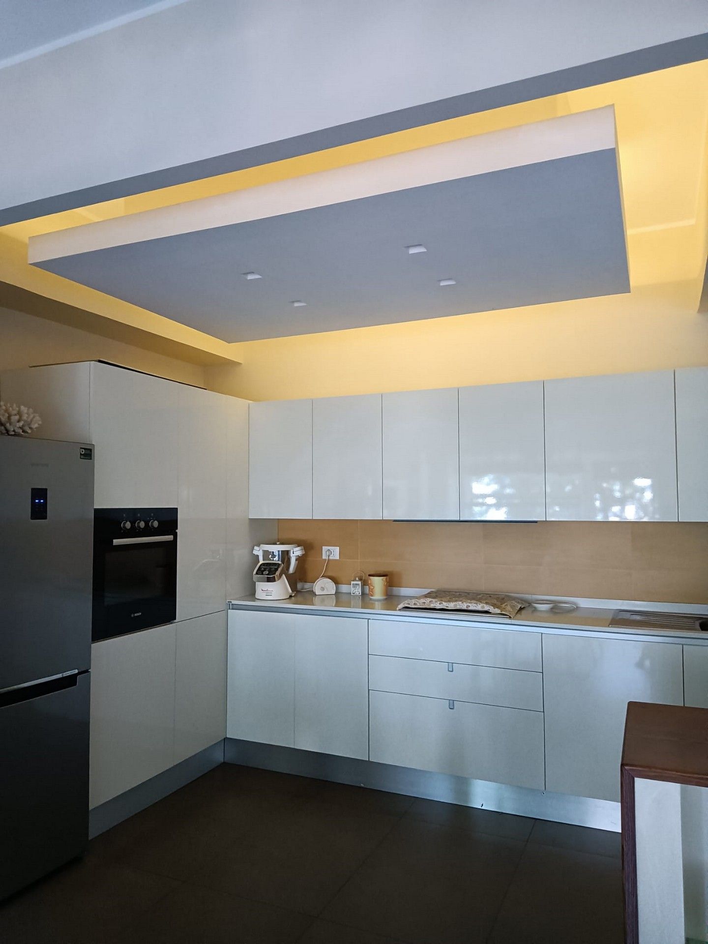 Una cucina con mobili bianchi ed elettrodomestici in acciaio inossidabile