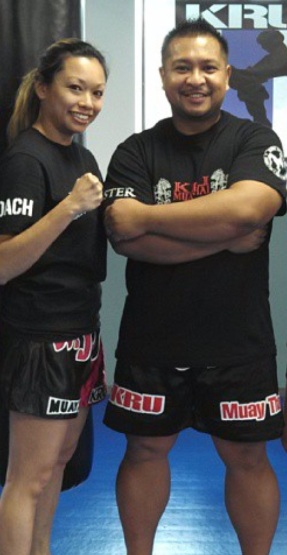 People practicing jiu-jitsu on mats, wearing gis in blue, black, and gray. Active grappling, gym setting.