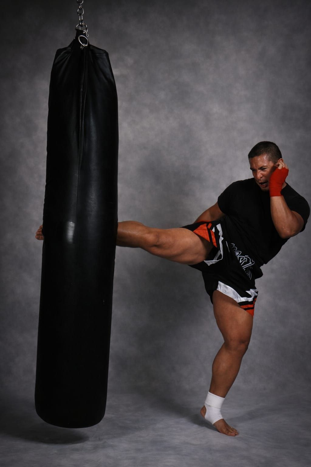 Two people practicing Brazilian Jiu-Jitsu on a mat; one in a black gi, one in a white gi, grappling.