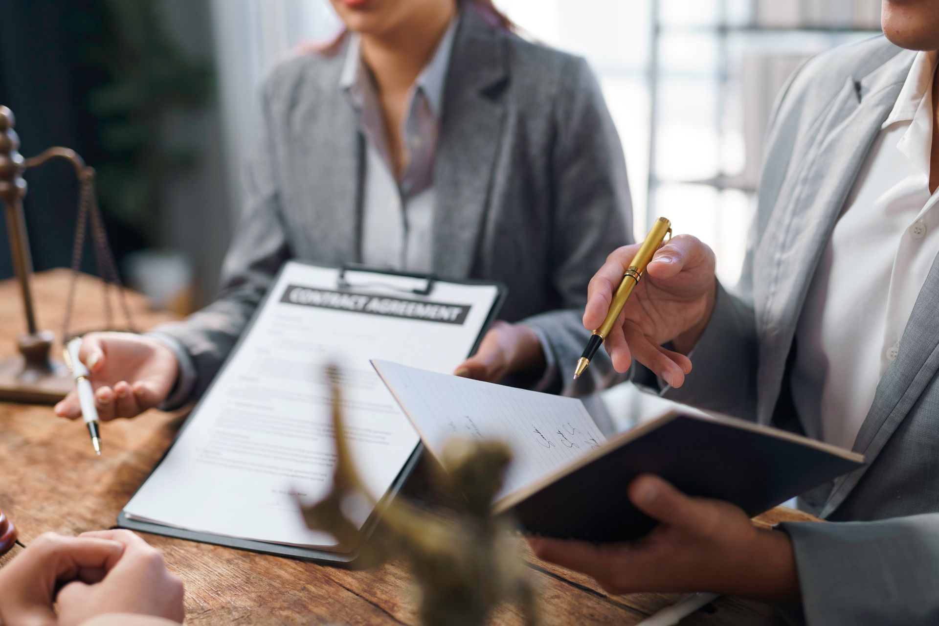 Lawyers reviewing documents and a contract agreement during a client meeting. Lawyers reviewing documents and a contract agreement during a client meeting.
