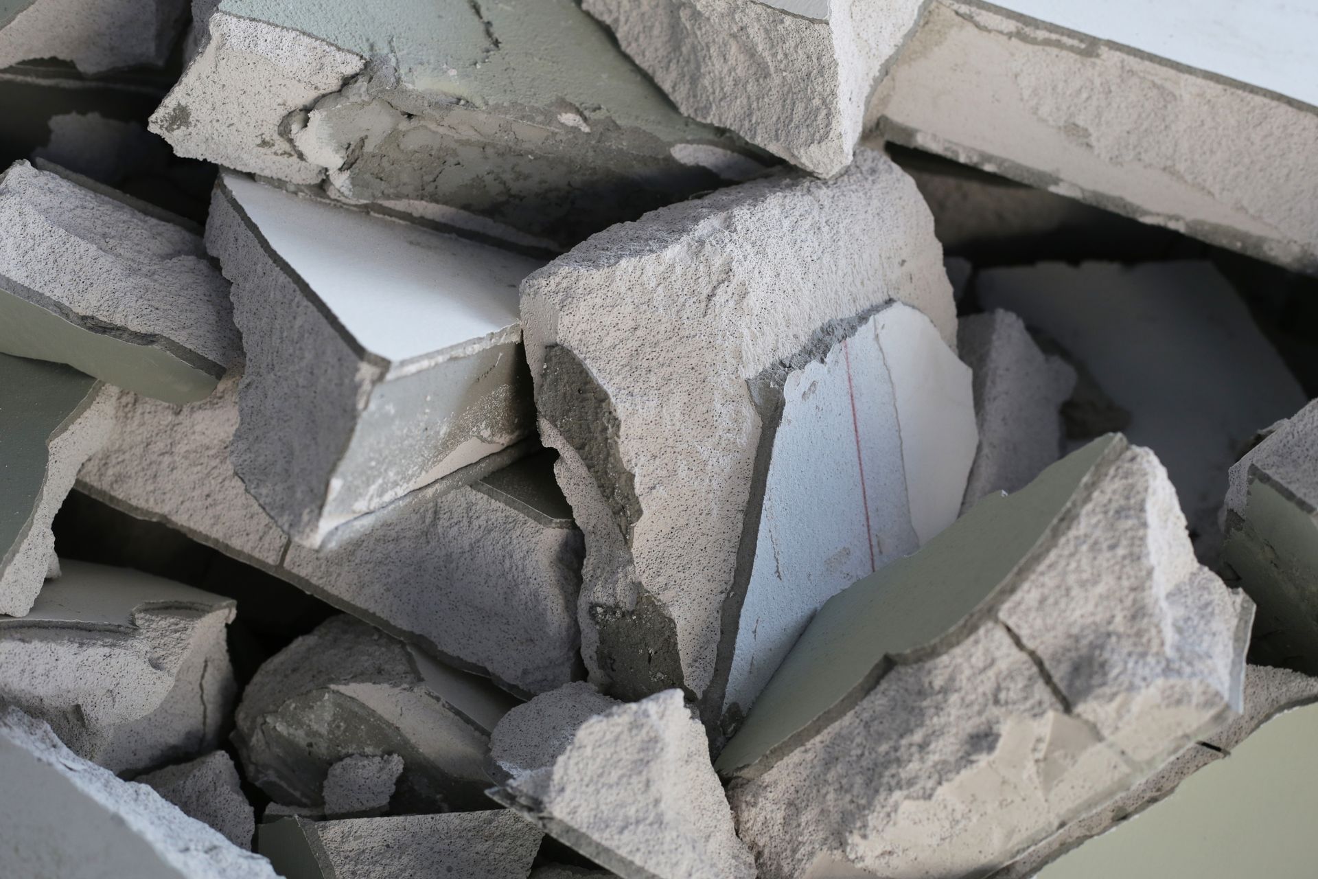 Broken concrete rubble with exposed white tile fragments.