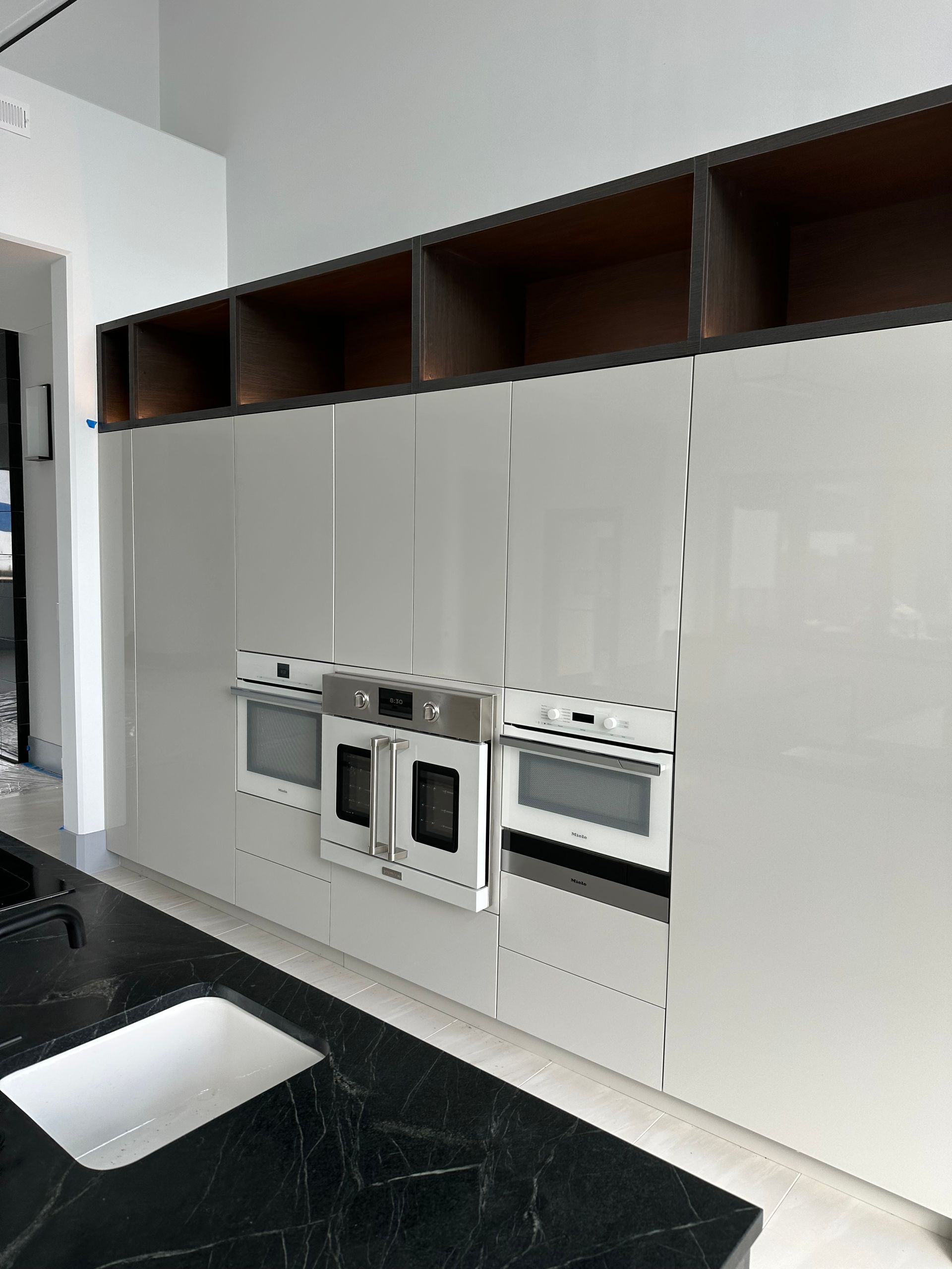 A kitchen with white cabinets and stainless steel appliances