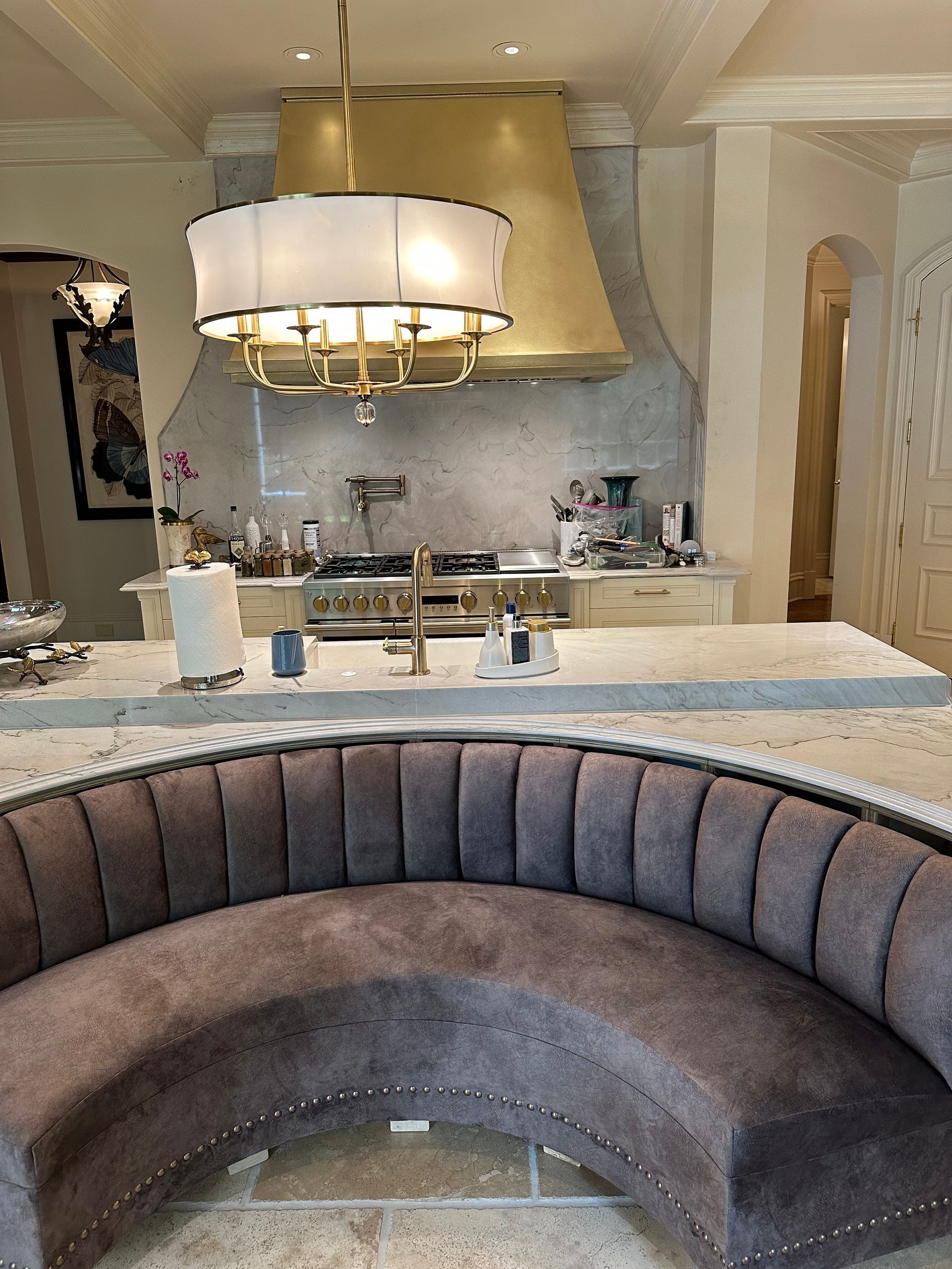 A kitchen with a curved couch and a chandelier
