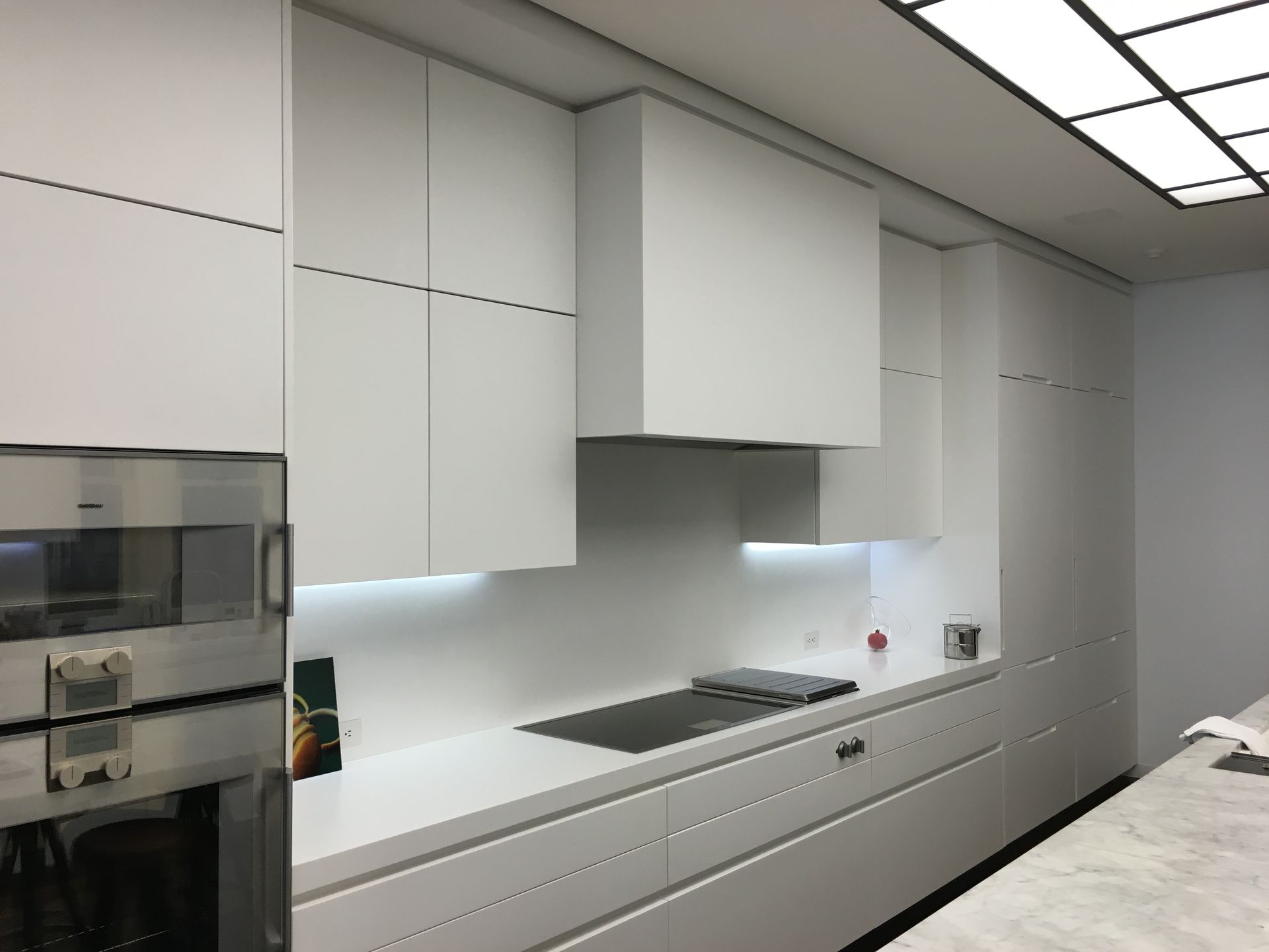 A kitchen with white cabinets and a stove top oven