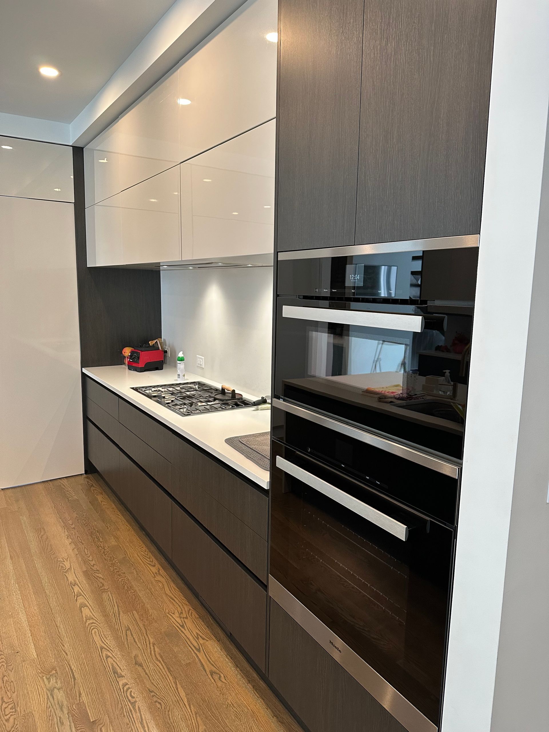 A kitchen with a stove , sink , and oven.
