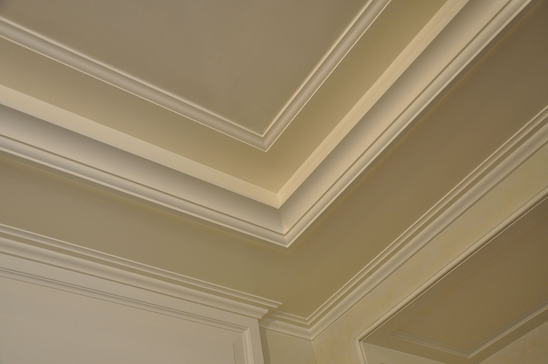 A close up of a ceiling with molding in a room.