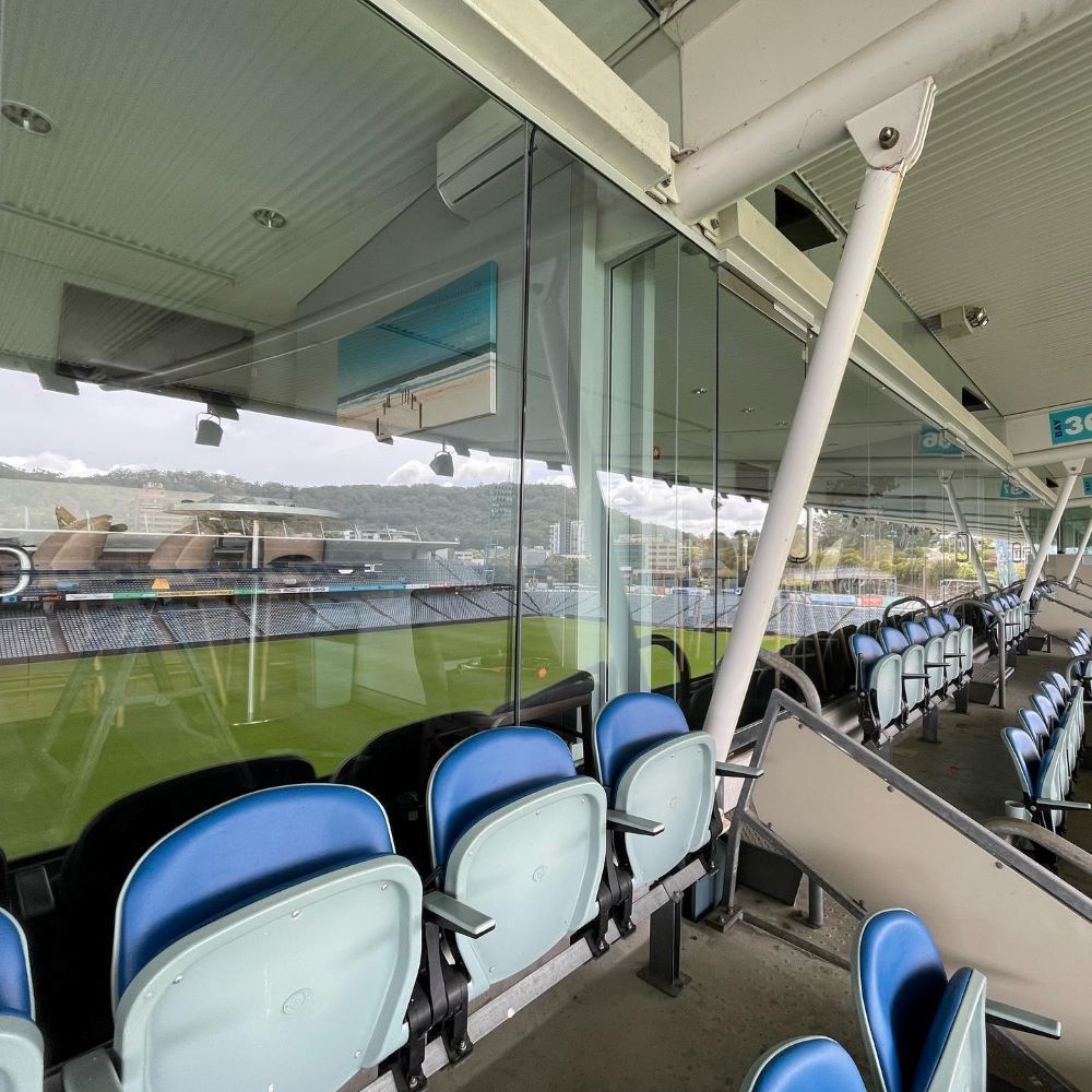 A Row of Blue Seats in a Stadium With a Glass Wall — Tuggerah Lakes Glass In Gosford, NSW