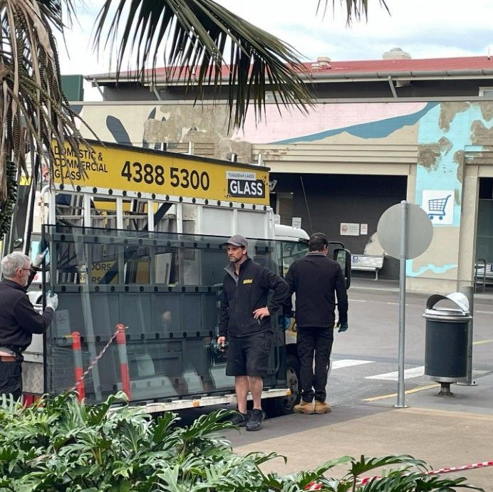 Three Workers Loading Glass Panels Onto a Truck — Tuggerah Lakes Glass In Tumbi Umbi, NSW