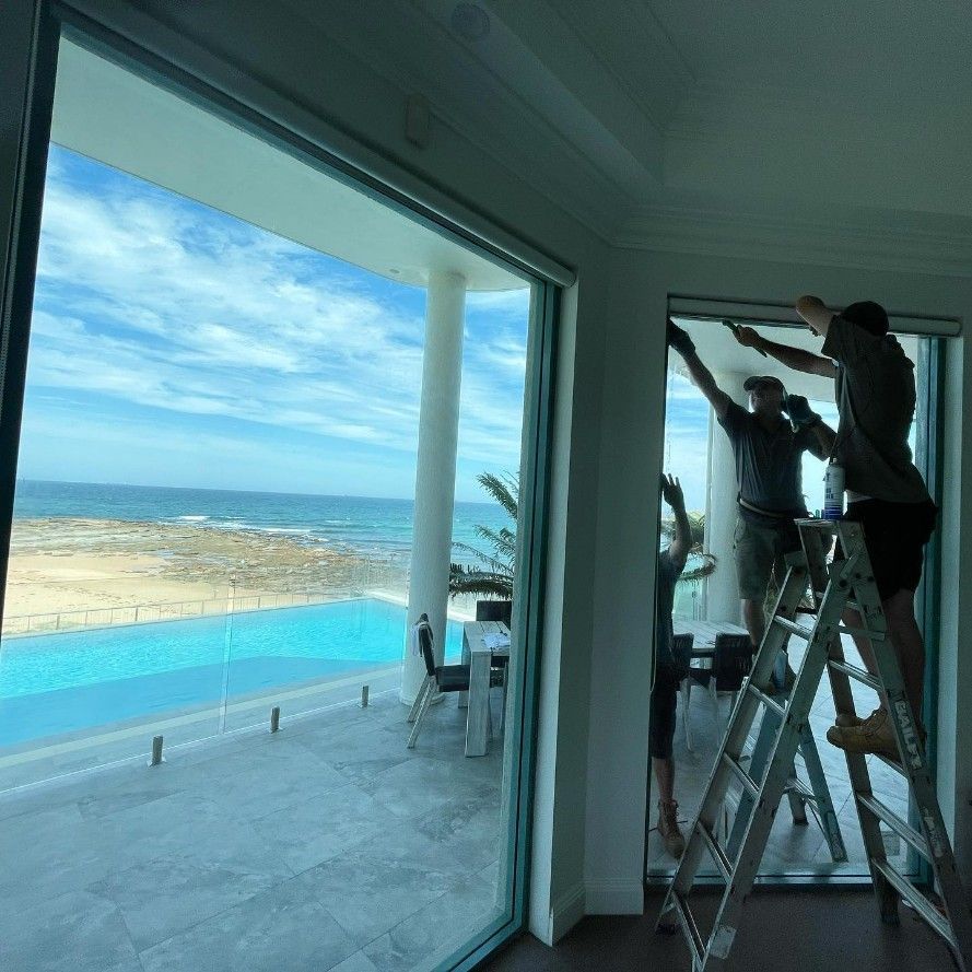 Workers Install Window Coverings in a Room — Tuggerah Lakes Glass In Tumbi Umbi, NSW