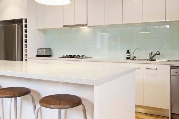 A Kitchen With White Cabinets, Stools, a Refrigerator and a Sink — Tuggerah Lakes Glass In Tumbi Umbi, NSW
