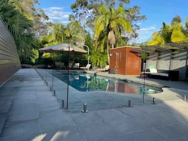A Large Swimming Pool With a Glass Fence Around It — Tuggerah Lakes Glass In Tumbi Umbi, NSW