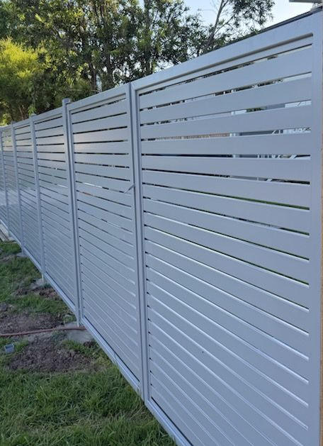 A Black Fence is Surrounding a Brick Driveway in a Residential Area — Fencing Around Town Townsville in Garbutt, QLD