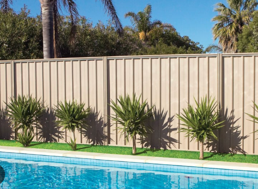 A Fence Surrounds a Swimming Pool With Palm Trees in the Background — Fencing Around Town Townsville in Garbutt, QLD