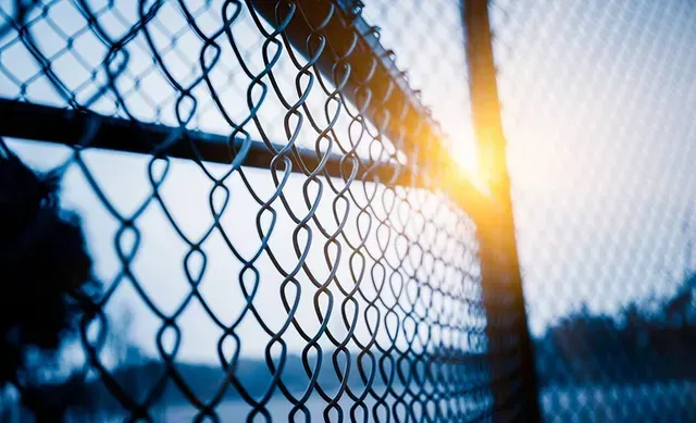 A Close up Of a Chain Link Fence with The Sun Shining Through It  — Fencing Around Town Townsville in Garbutt, QLD