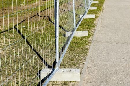 A Fence is Sitting on the Side of a Road Next to a Grassy Field — Fencing Around Town Townsville in Garbutt, QLD
