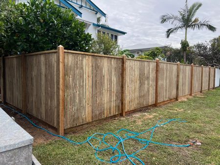 A Wooden Fence with A Lattice Design Is Surrounded by Tall Grass and Trees — Fencing Around Town Townsville in Garbutt, QLD