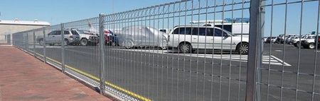 A Fence is Sitting on the Side of a Road Next to a Grassy Field — Fencing Around Town Townsville in Garbutt, QLD