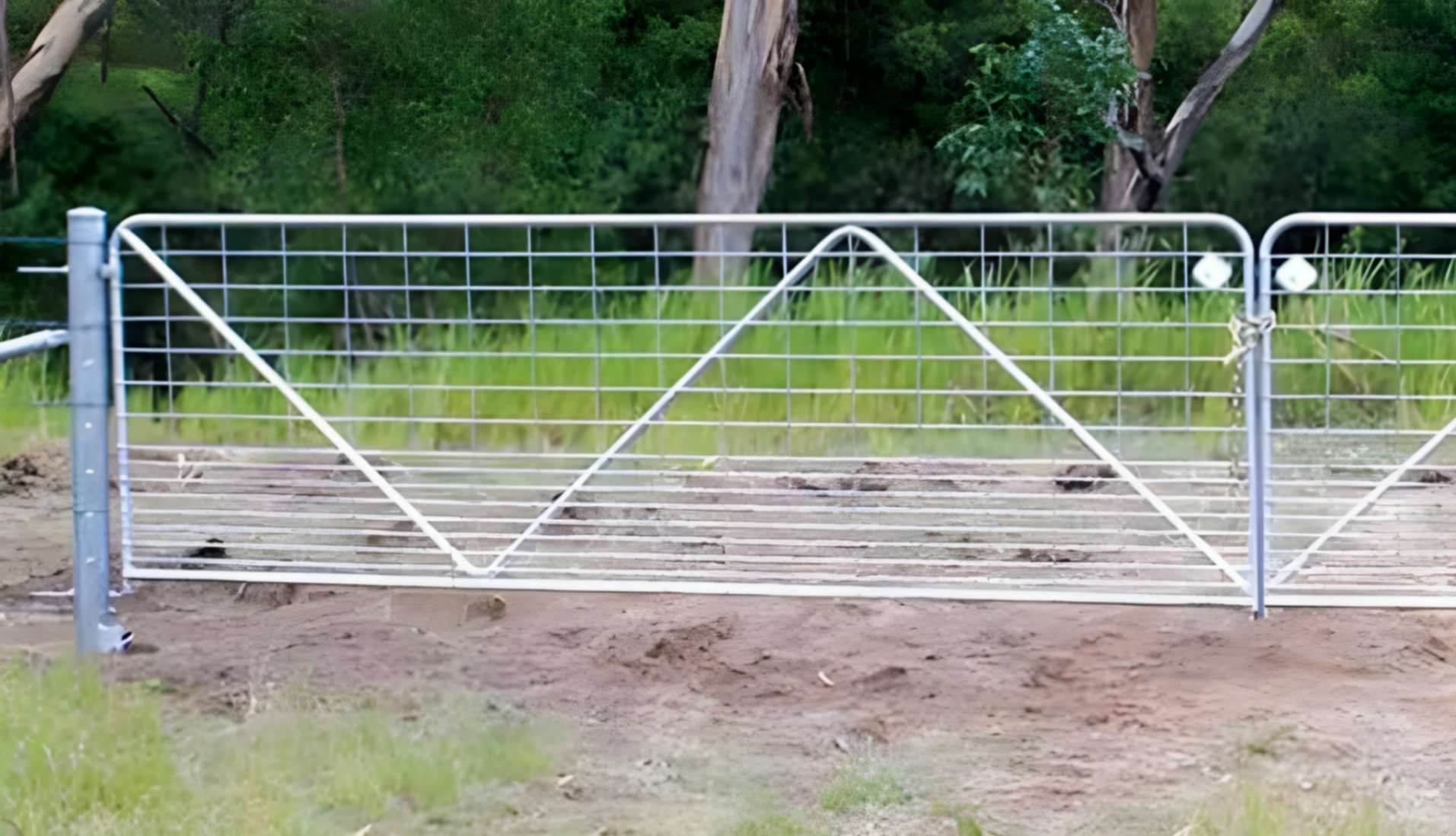 A Metal Gate is Sitting in the Middle of a Grassy Field — Fencing Around Town Townsville in Garbutt, QLD