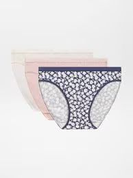 Una pila di tre paia di slip da donna, uno bianco, uno rosa tenue e uno con stampa floreale bianca e blu scuro.